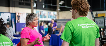 2 people in neon T-Shirts with logo of the NSF Energy Storage Engine at an exhibition