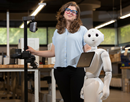 Assistant Professor Stephanie Tulk Jesso posing with robot