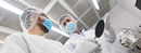 Researchers in cleanroom protective gear operating equipment in a nanofabrication lab