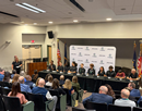 Audience gathered for a panel discussion, with speakers seated at a long table in front of a Micron and NY CREATES backdrop