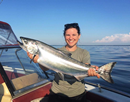 SUNY Oswego biological sciences faculty member Ellen Karboski holds an adult chinook caught on Lake Ontario