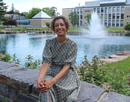Dr. Akanksha Misra sitting in front of Hudson Hall Science Complex at SUNY Plattsburgh