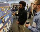 Student explains research that is on poster to member of SUNY Poly community