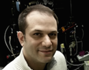 Headshot of professor Joshua Plotkin from Stony Brook University in front of microscope