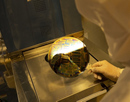 A person in white PPE demonstrates a new state-of-the-art chip design tool