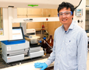 UAlbany's Qiang Zhang, associate professor in the Department of Chemistry, uses an instrument called a solid phase peptide synthesizer to build proteins being explored for future biomedical applications
