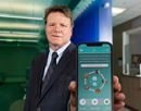 University of Buffalo distinguished professor Ralph Benedict holding a phone displaying his Conscientiousness Coach application