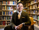 Assistant professor Óscar F. Gil-García sitting in a library