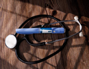 A GLP-1 injector and a stethoscope on a wooden surface
