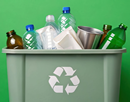 Recycling bin full of plastic bottles glass jars and metal cans on green background