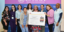 Staff from Upstate Medical University Hospital holding an award from American Heart Association standing in front of an Upstate banner