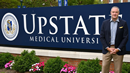 Interim Vice President for Research standing in front of Upstate Medical University